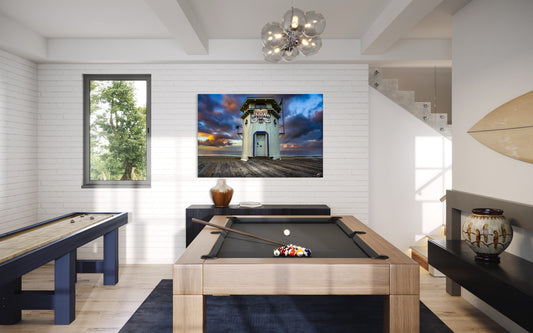 A dramatic coastal sunrise over the historic Laguna Beach lifeguard tower. Vibrant clouds, ocean light, and Southern California charm in a fine art print.