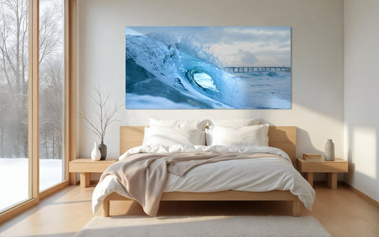 A powerful ocean wave forms a crystalline barrel at sunrise with a pier in the distance. A dynamic coastal surf moment captured in soft blue light.
