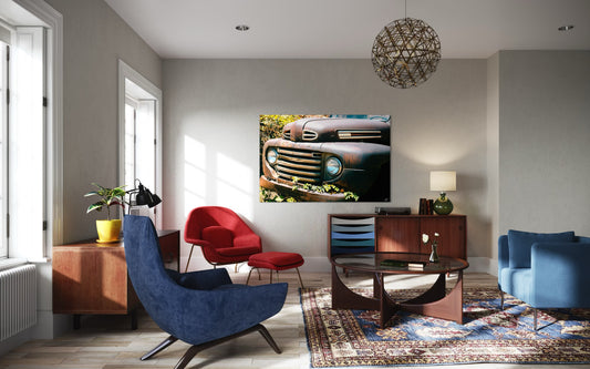 Modern living room with blue and red chairs, a coffee table, and a decorative wall art of a car grille.