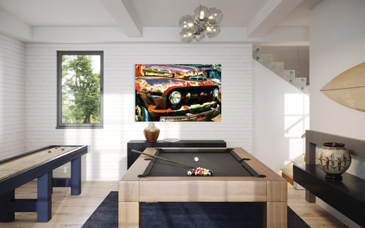 Modern room with pool table, wall art of a car, and window with view outside.
