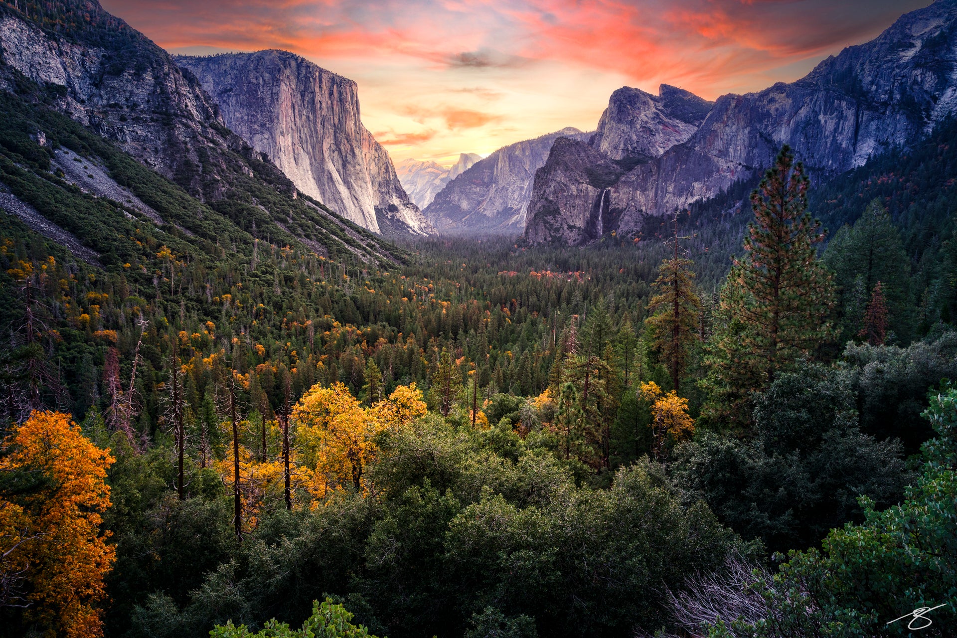 Sunset panorama of Yosemite Valley with El Capitan on the left, Bridalveil Fall on the right, Half Dome in the distance, and autumn trees filling the forest below