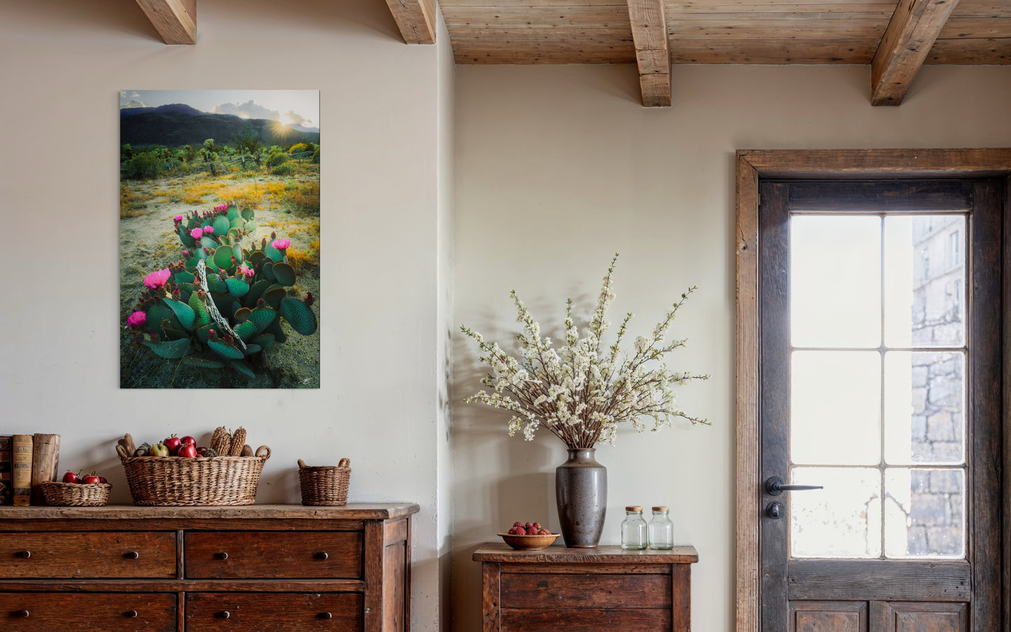 Beavertail cactus in vibrant pink bloom at sunrise with desert vegetation, mountains, and golden morning light.