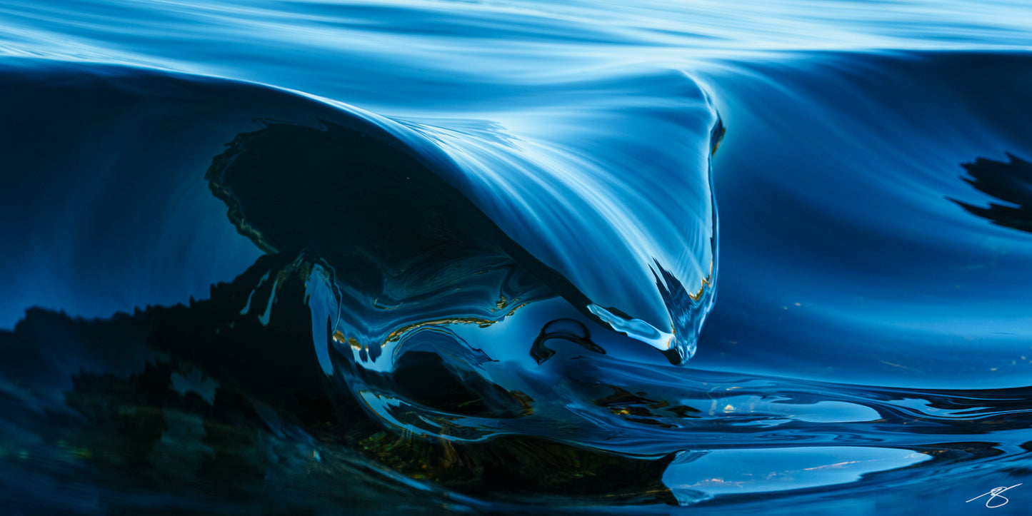 This close-up of a glassy wave captures the exact moment a cobalt crest folds into a sleek, mirror-like curve—an ocean abstract that feels both powerful and calming. Deep blues, chrome highlights, and minimalist lines make this a statement piece for modern coastal décor, offices, and spa-like spaces