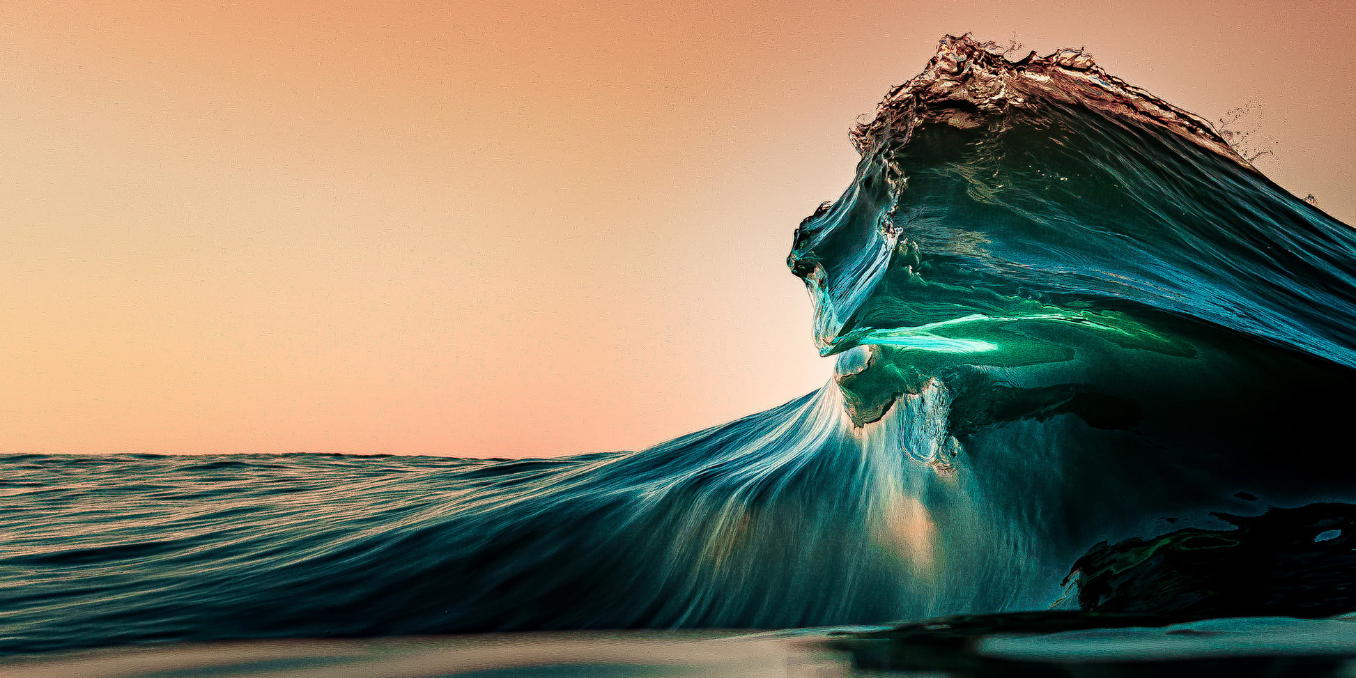 Breaking ocean wave glowing with emerald light at sunrise, fine art seascape photograph by Beau Jesse Johnston.