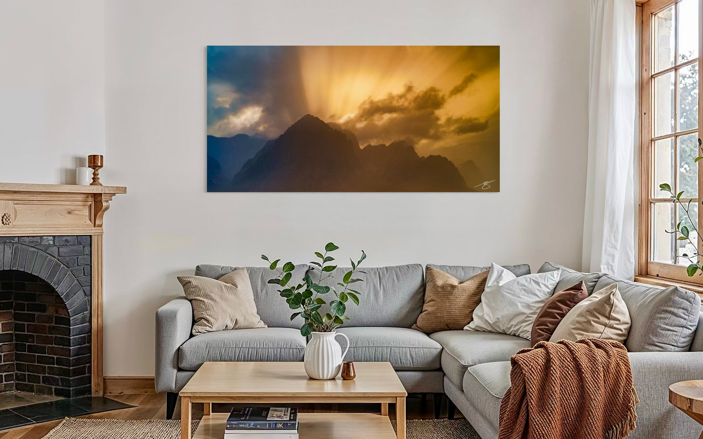 Living room with a sectional sofa, coffee table, and a large mountain painting on the wall.