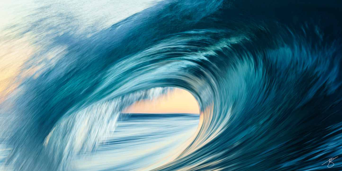 Abstract long-exposure of a curling ocean barrel at sunrise with teal blues and a warm golden glow visible through the wave
