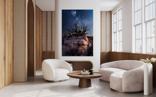 Modern living room with white chairs, a wooden coffee table, and a large wall art piece.