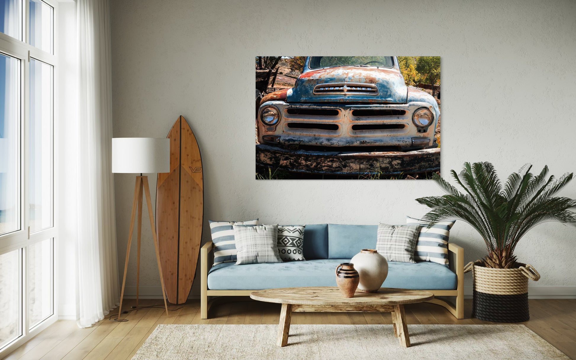 Living room with a large wall art of an old truck, sofa, coffee table, and decor items.