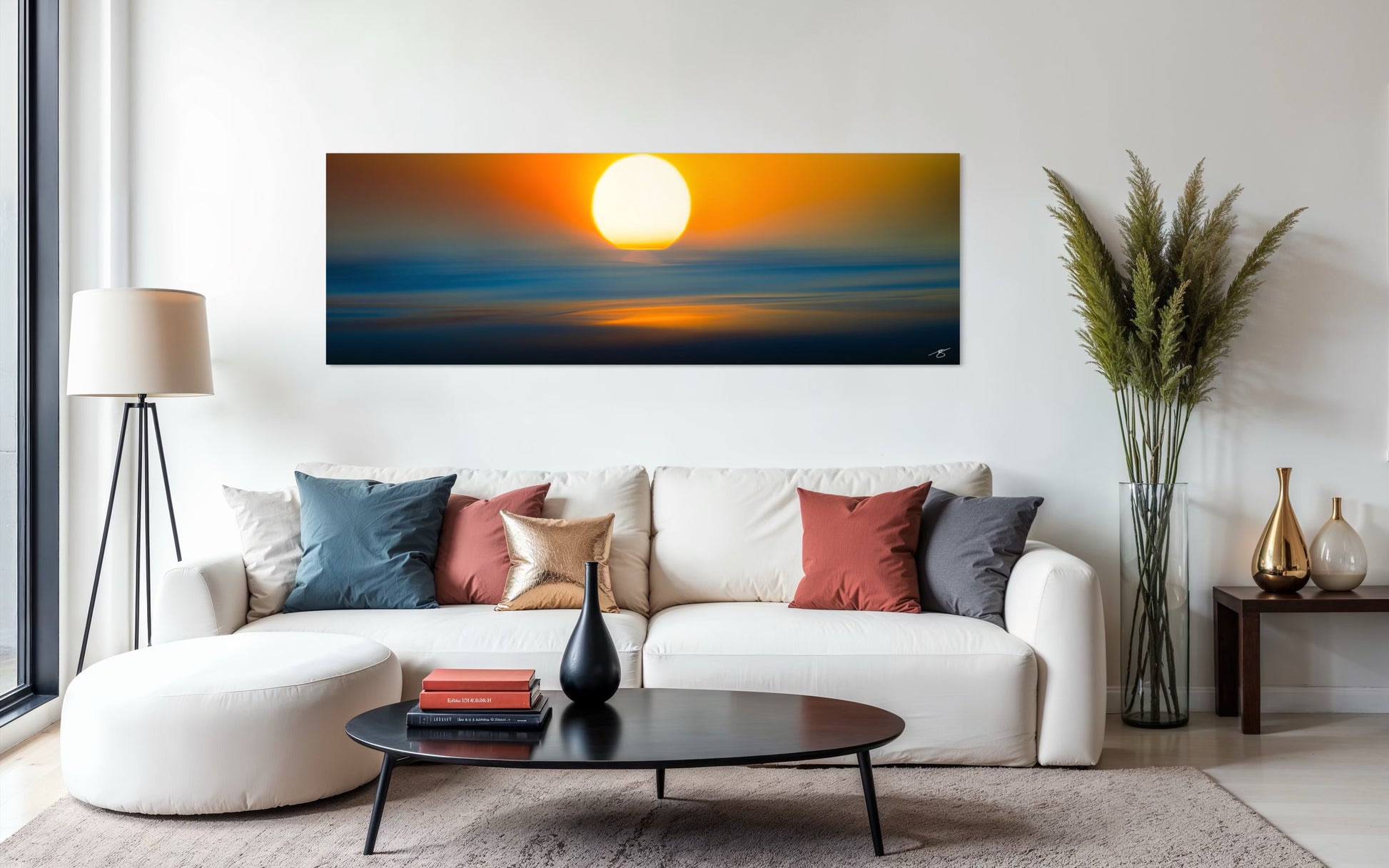 Living room with a white sofa, coffee table, and a large sunset painting on the wall.