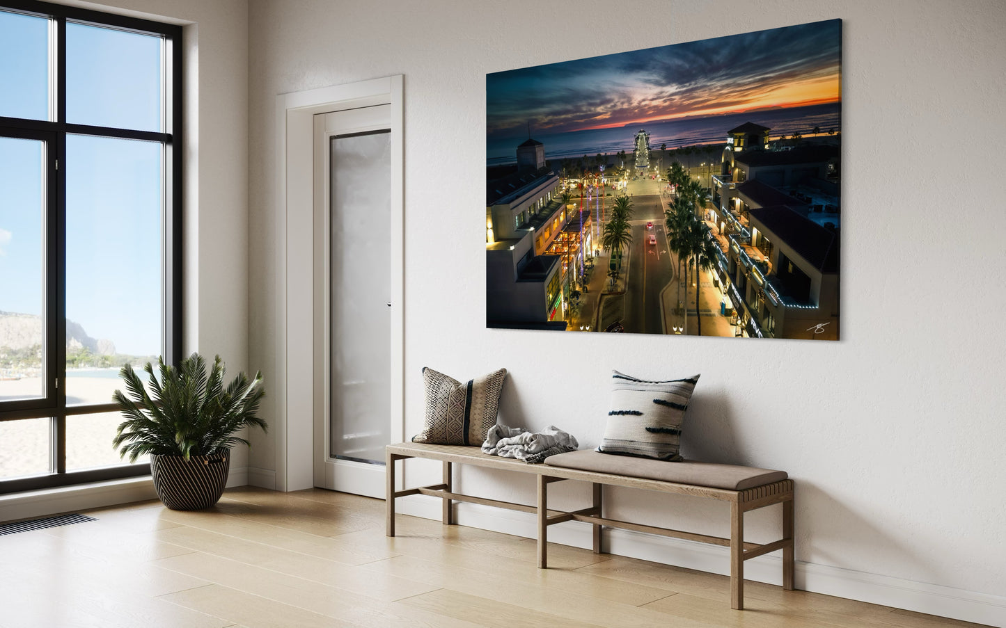 Aerial sunset view of Huntington Beach Pier with glowing ocean, illuminated streets, and vibrant coastal city lights.