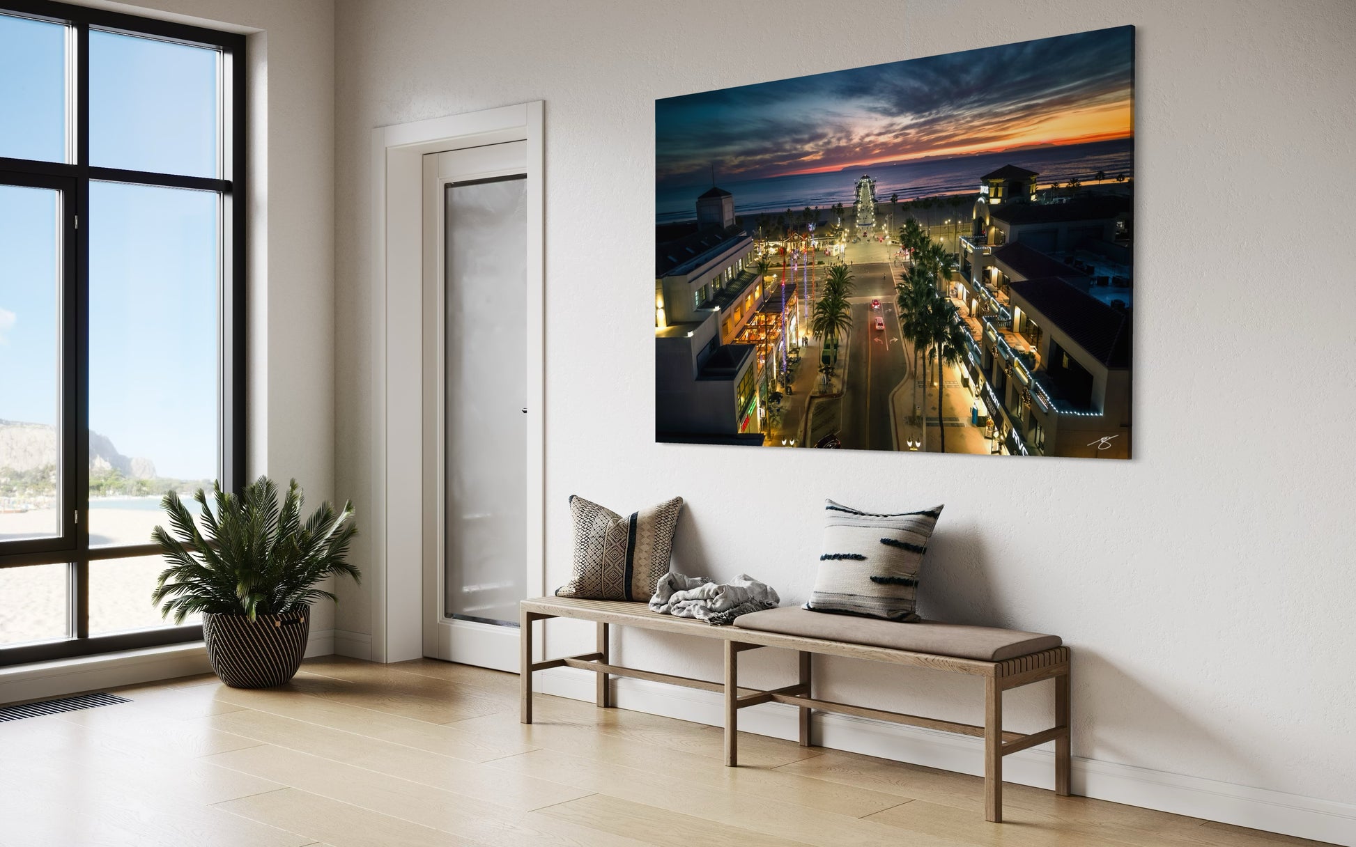 Aerial sunset view of Huntington Beach Pier with glowing ocean, illuminated streets, and vibrant coastal city lights.