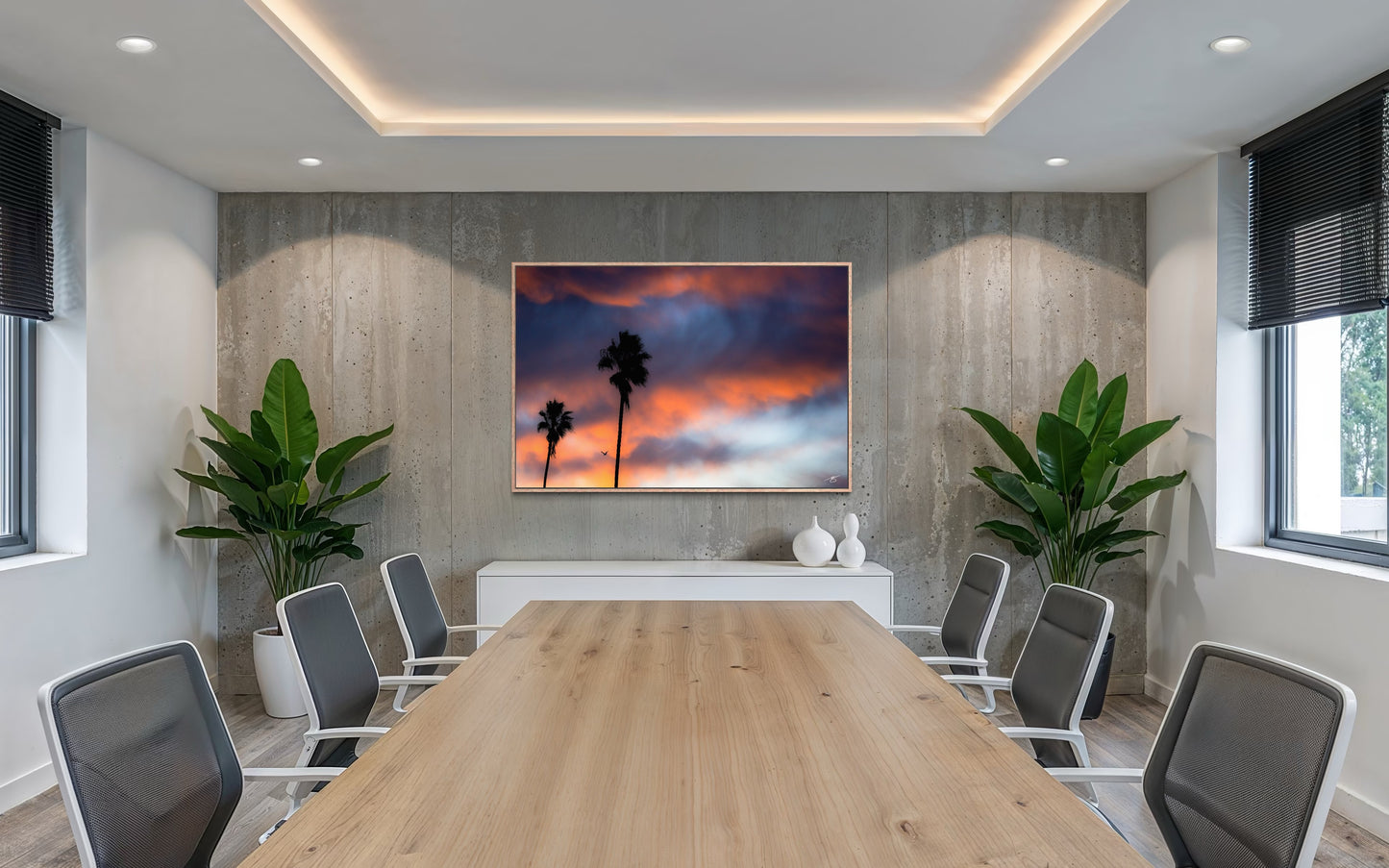 California sunrise sky with silhouetted palm trees and a bird flying beneath vibrant orange and blue clouds.