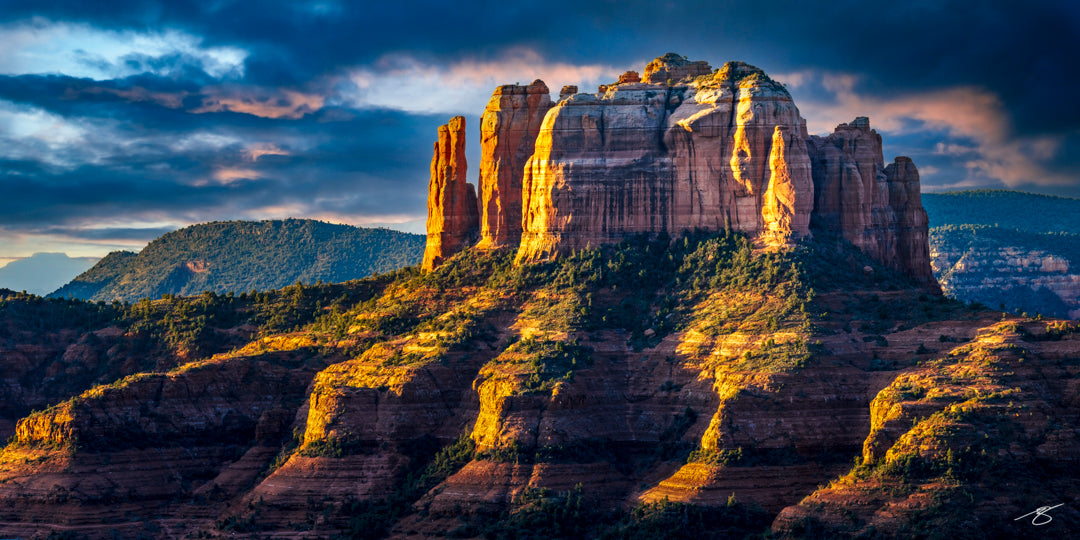 Fine art sunrise photograph of Cathedral Rock in Sedona, Arizona, capturing warm golden light illuminating red rock cliffs, rugged formations, and dramatic clouds. A vivid Southwest landscape showcasing depth, texture, and iconic desert scenery.