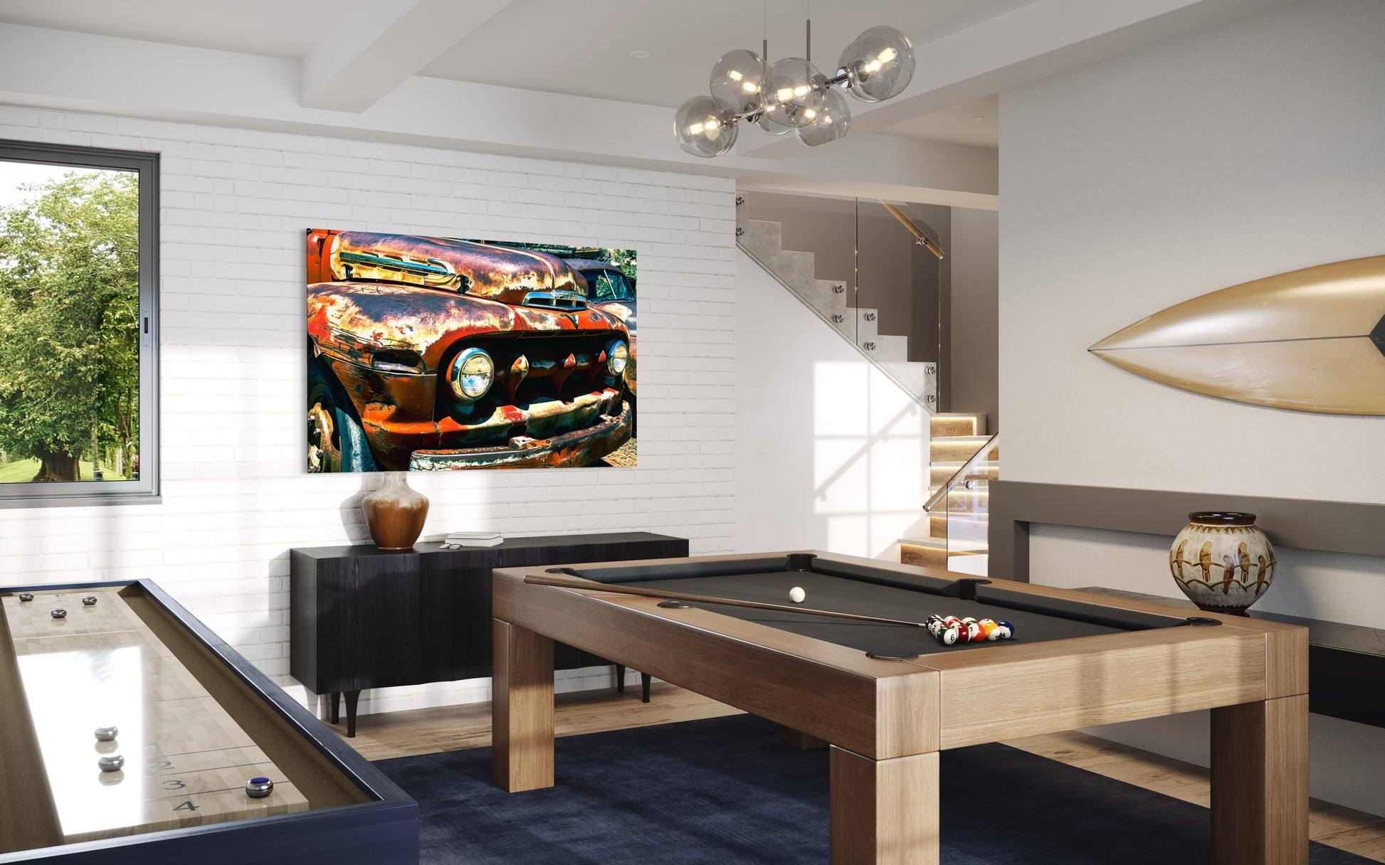 Modern living room with pool table, foosball table, and abstract painting on wall.