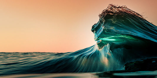 Breaking ocean wave glowing with emerald light at sunrise, fine art seascape photograph by Beau Jesse Johnston.