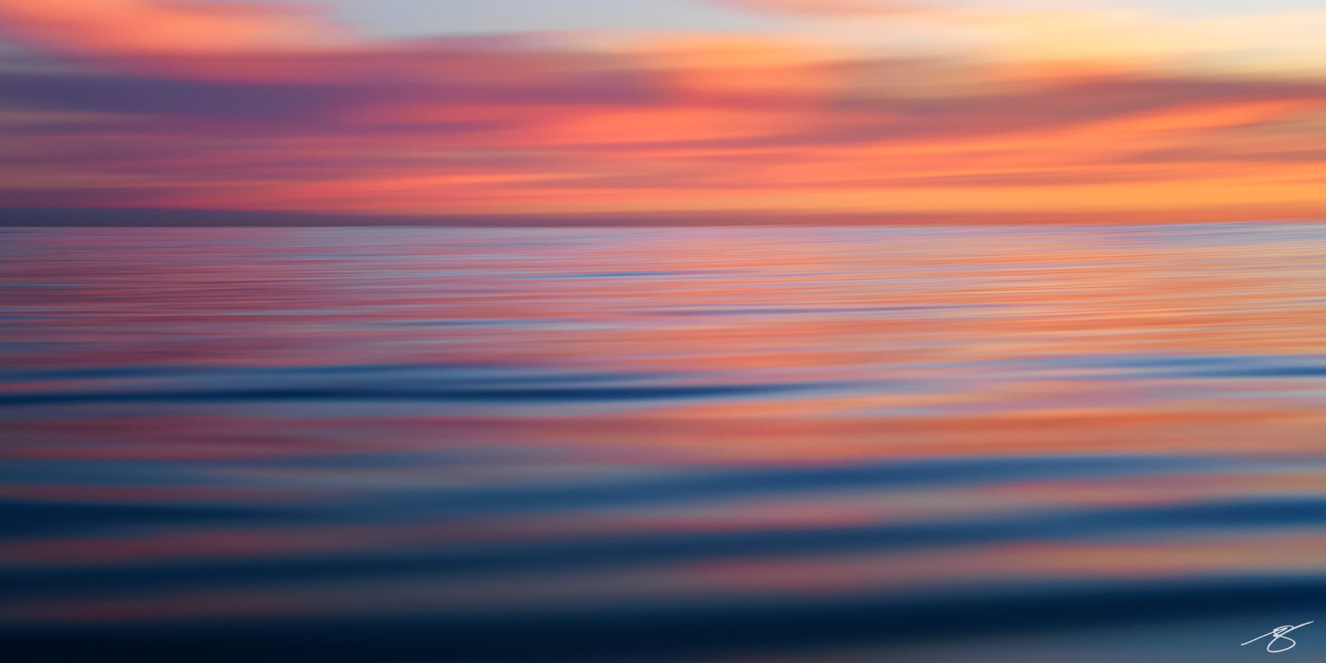 Abstract pastel reflections of sunset on calm Pacific waters blending pink, orange, and blue tones.