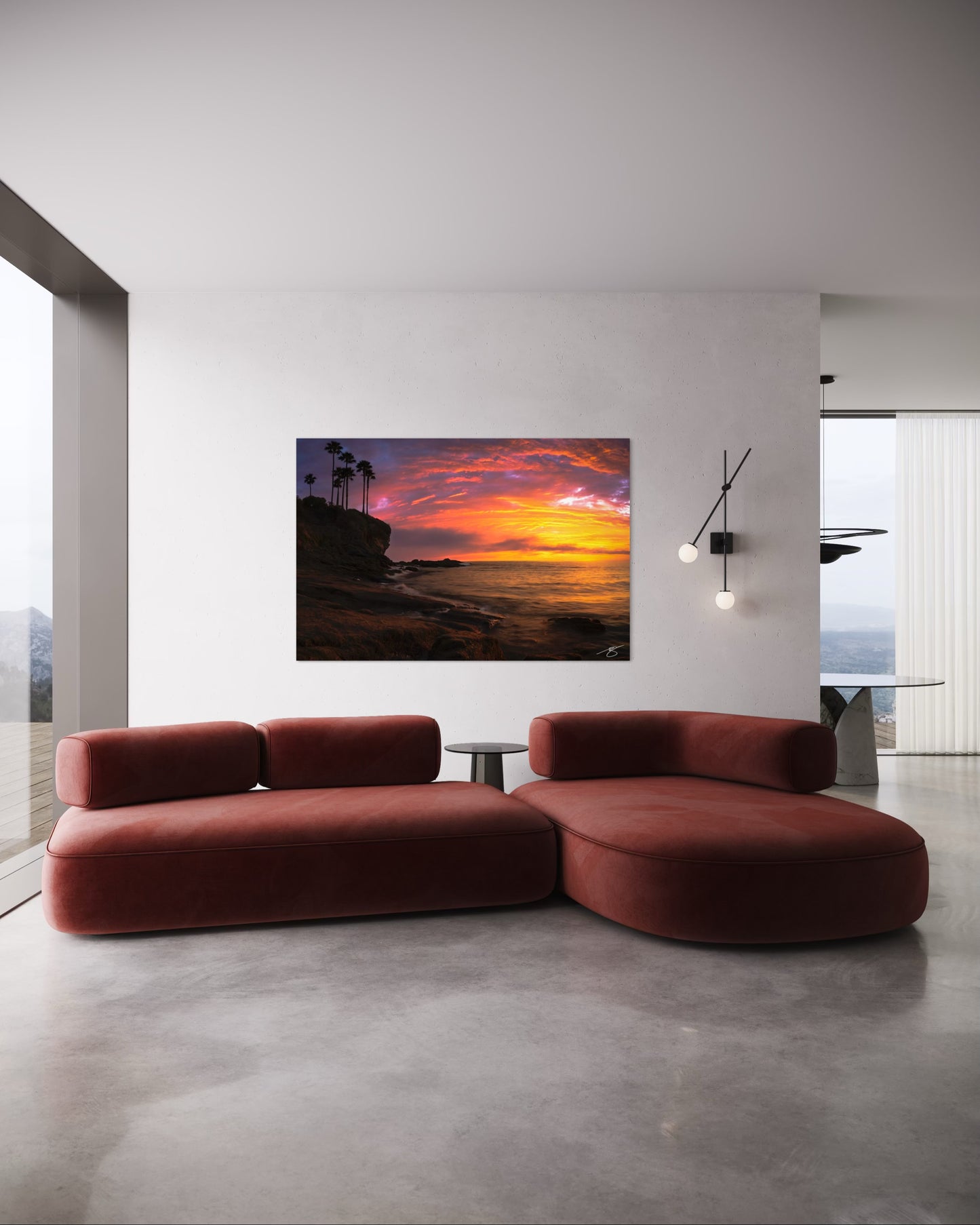 Modern living room with a red sofa and a large sunset painting on the wall.