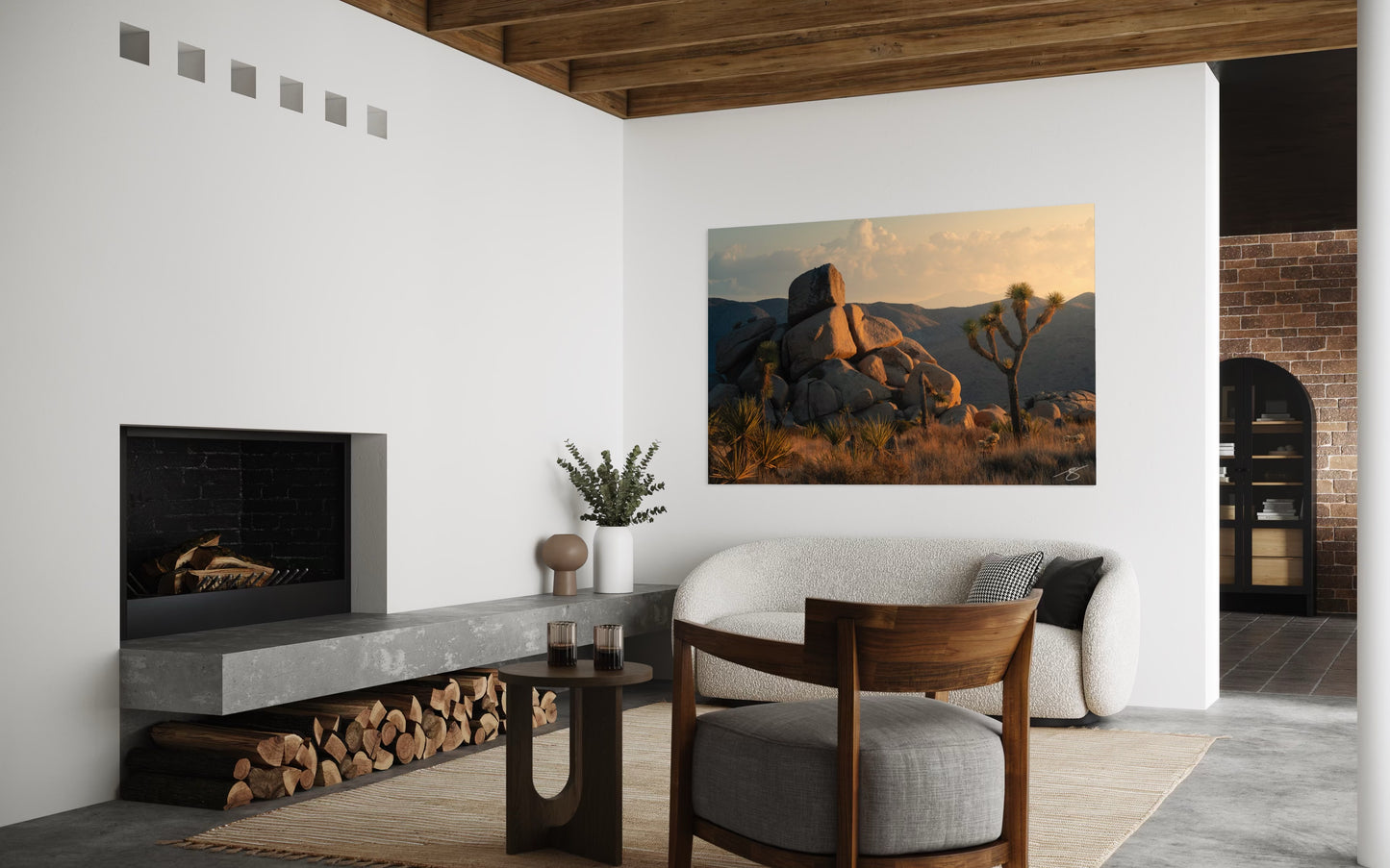 Modern living room with a fireplace, chair, and wall art of a desert landscape.