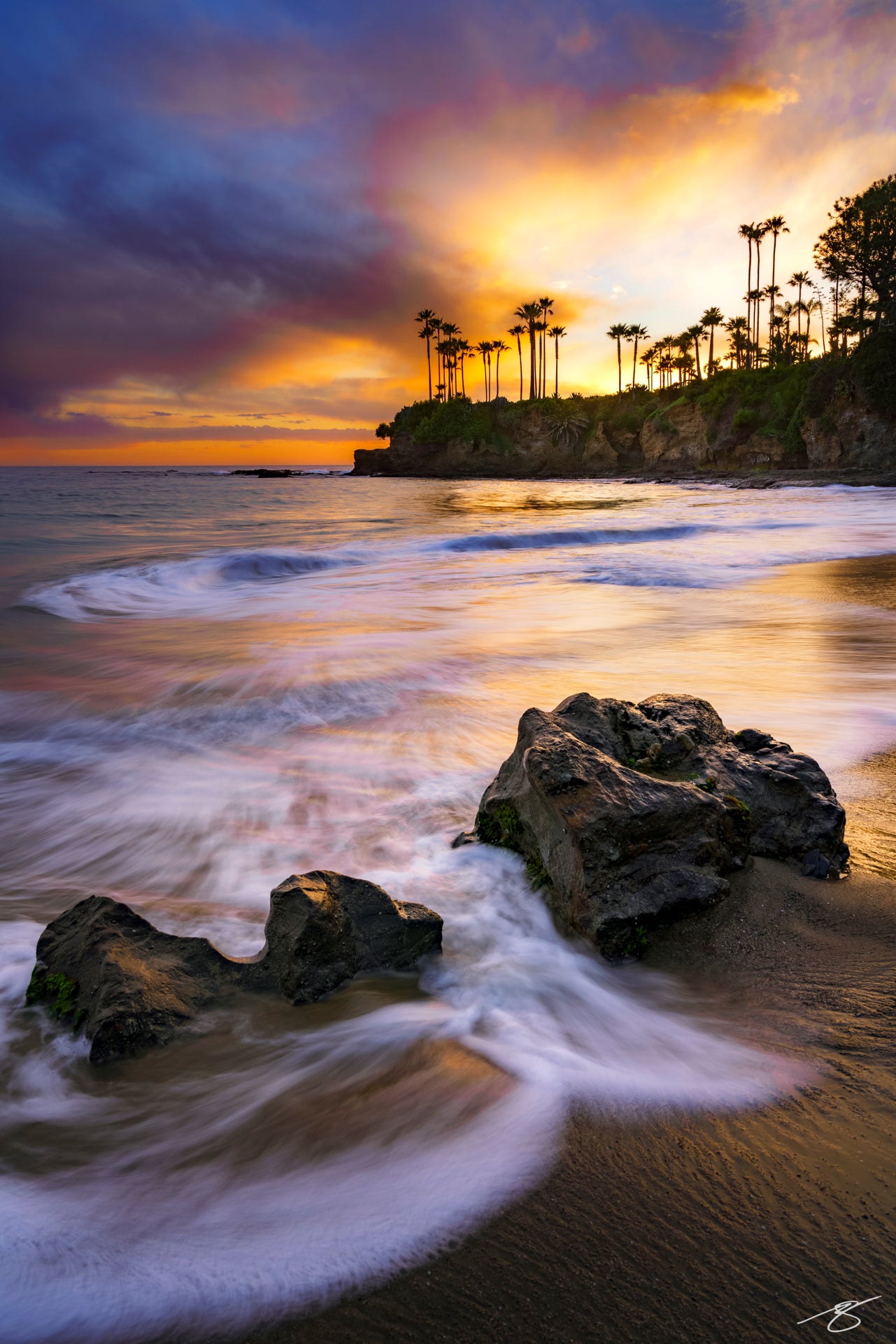 Sunset waves and glowing sky along Laguna Beach’s rocky shoreline at Heisler Park, California
