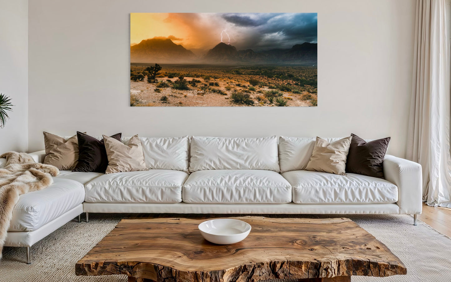 Living room with a white sofa, wooden coffee table, and a large desert landscape painting on the wall.