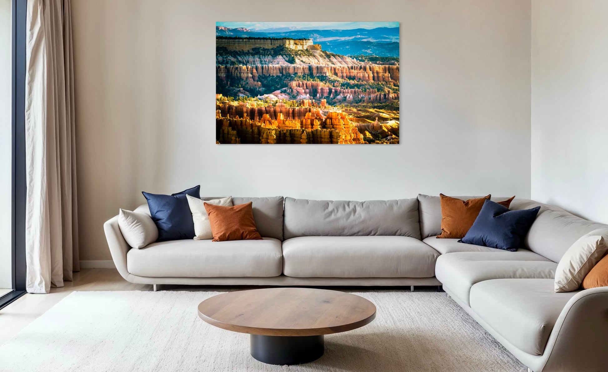 Living room with a large sofa, coffee table, and wall art of a canyon.