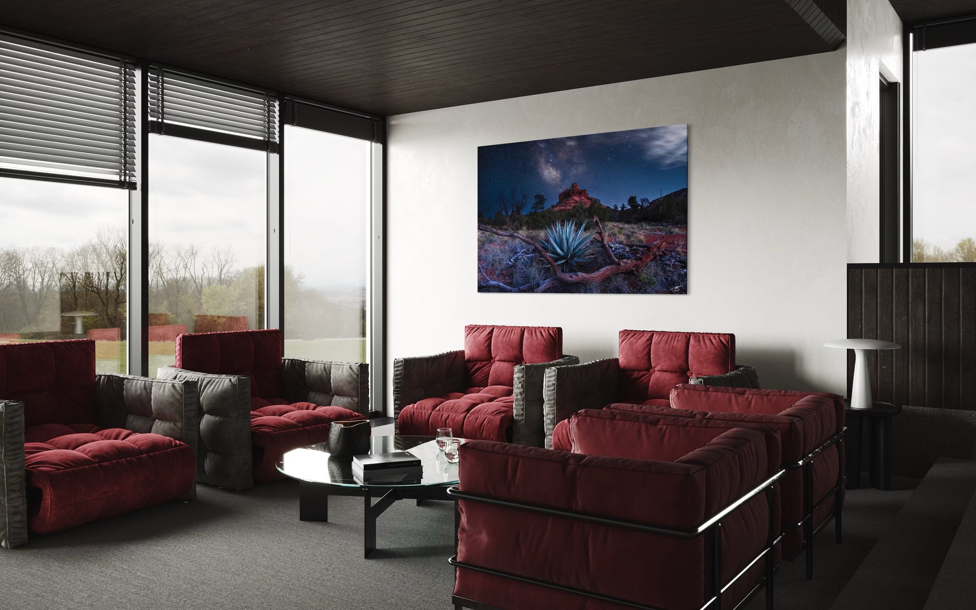 Modern living room with red sofas, a coffee table, and a large painting on the wall.