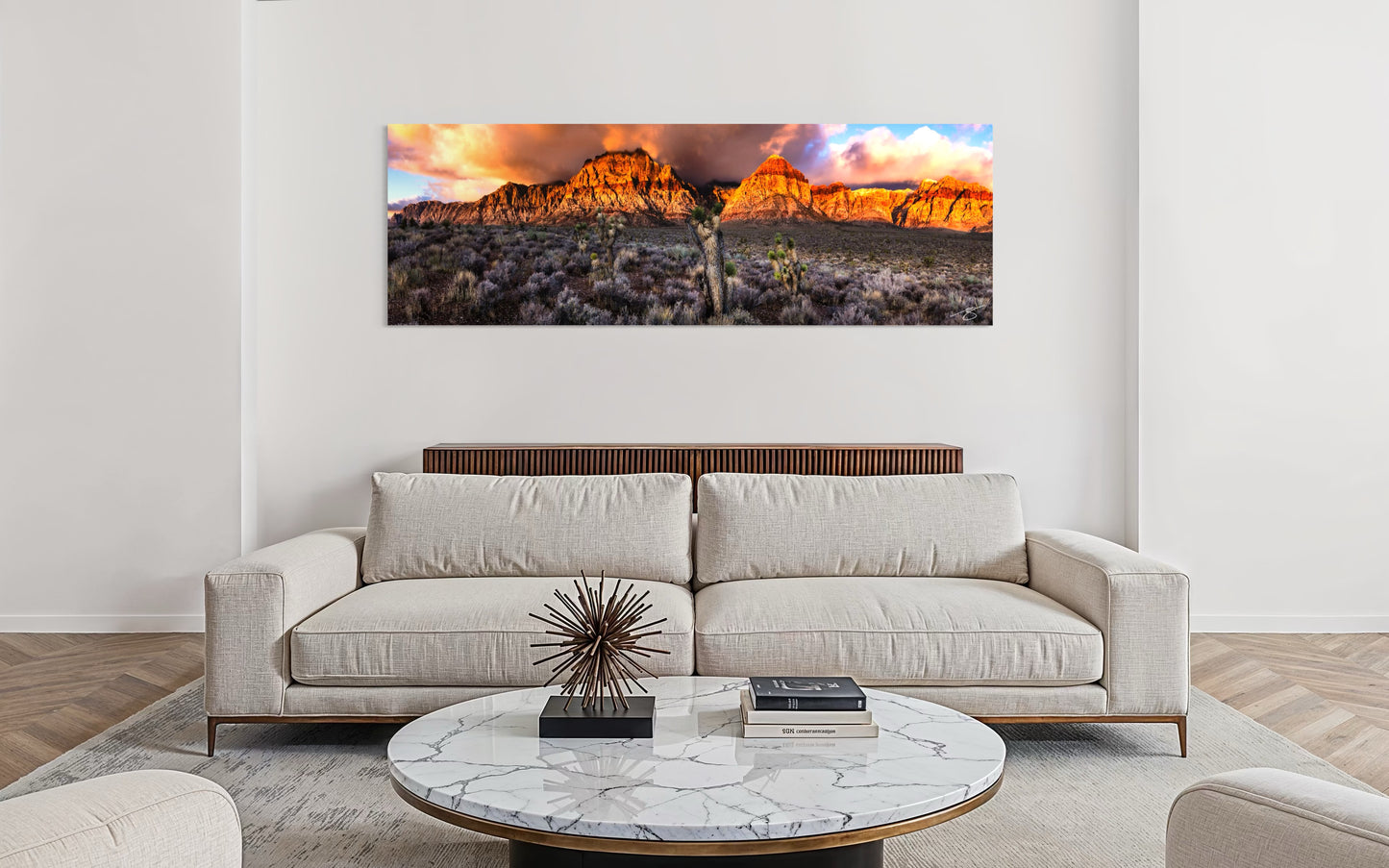 Sunrise illuminating Red Rock Canyon cliffs with Joshua Trees in the Nevada desert under glowing clouds.