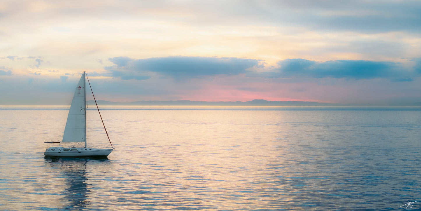 Fine art sailboat photograph at sunset on calm ocean waters by Beau Jesse Johnston, coastal wall art.
