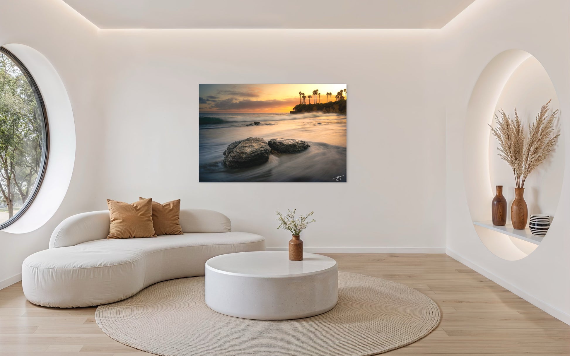 Sunset over Laguna Beach with soft ocean motion, rocky shoreline, and silhouetted palm trees along the California coast.