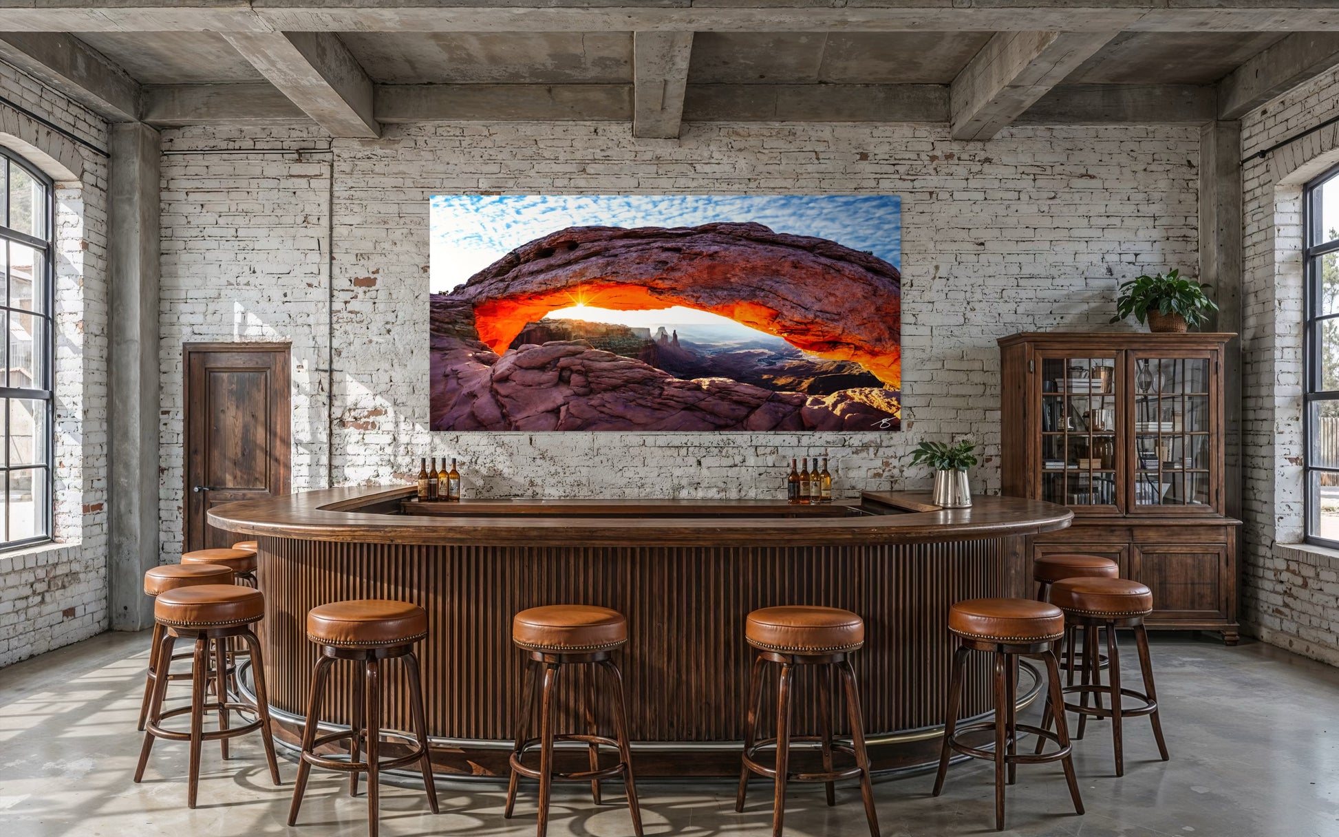Sunrise glowing beneath Mesa Arch with a sunburst and wide canyon views in Canyonlands National Park.