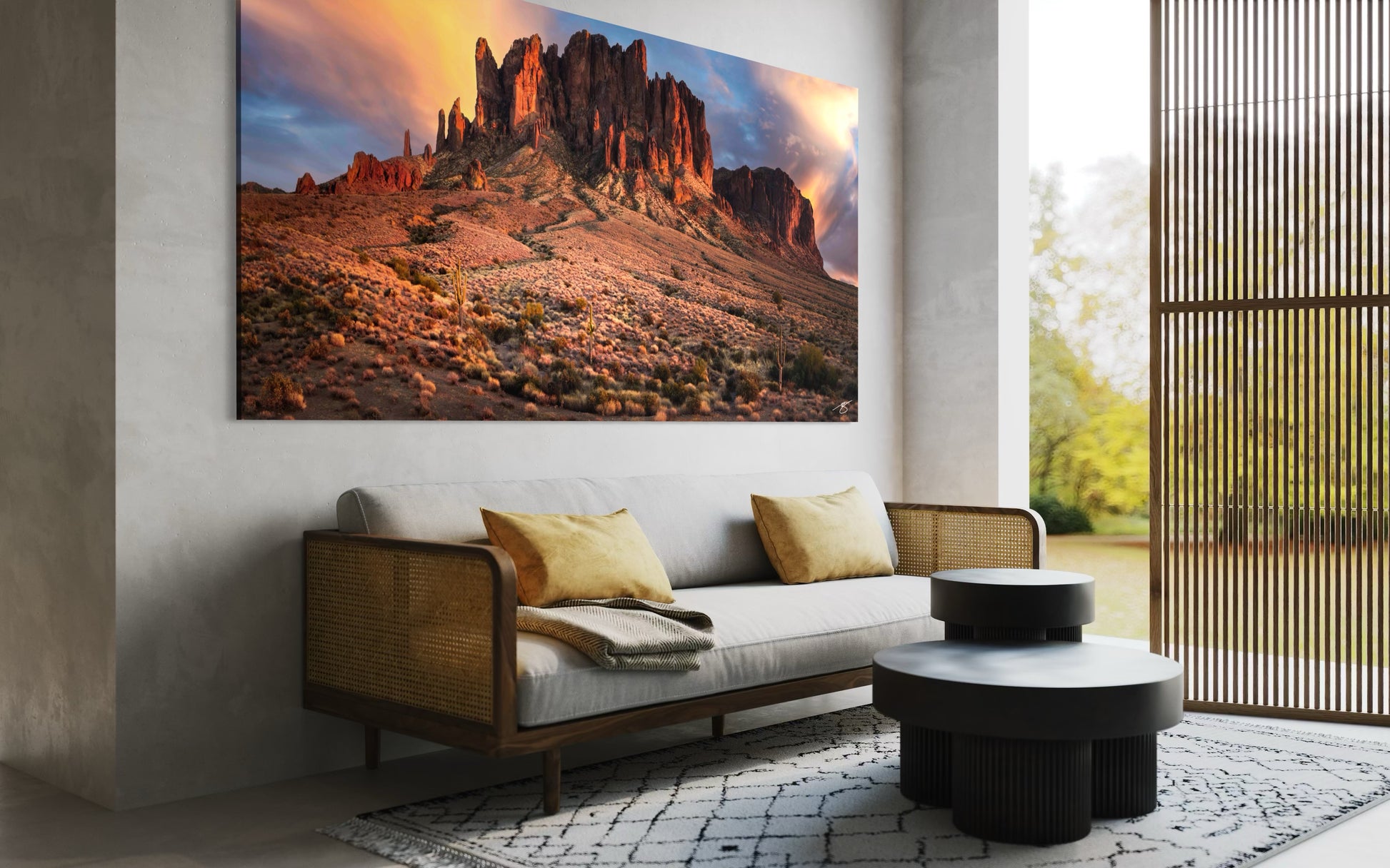 Sunset light illuminating the Superstition Mountains in Arizona with desert cacti and brush in a wide panoramic landscape.