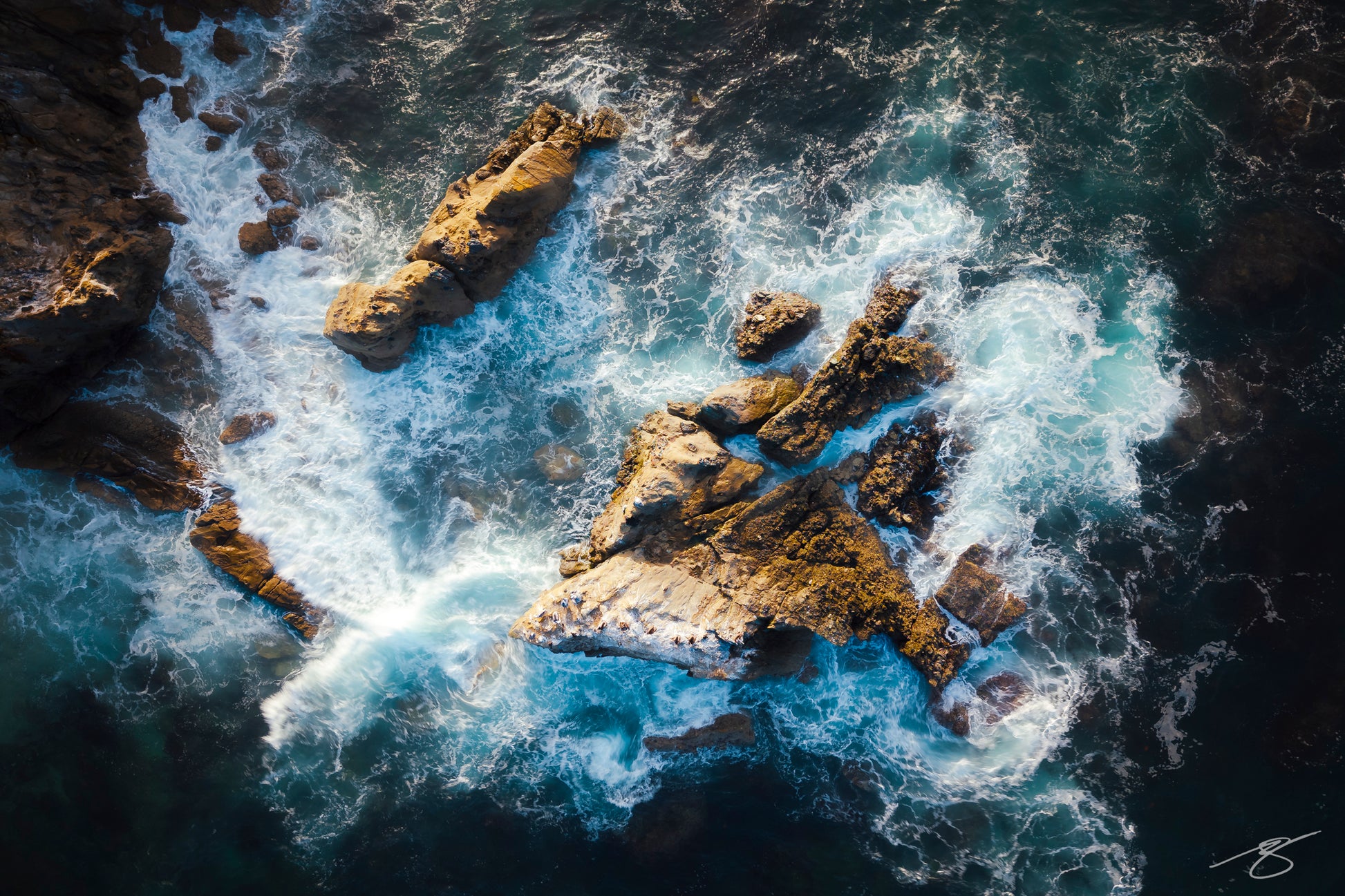 Aerial view of waves crashing over Laguna Beach rocks – fine-art coastal photography by Beau Jesse Johnston.