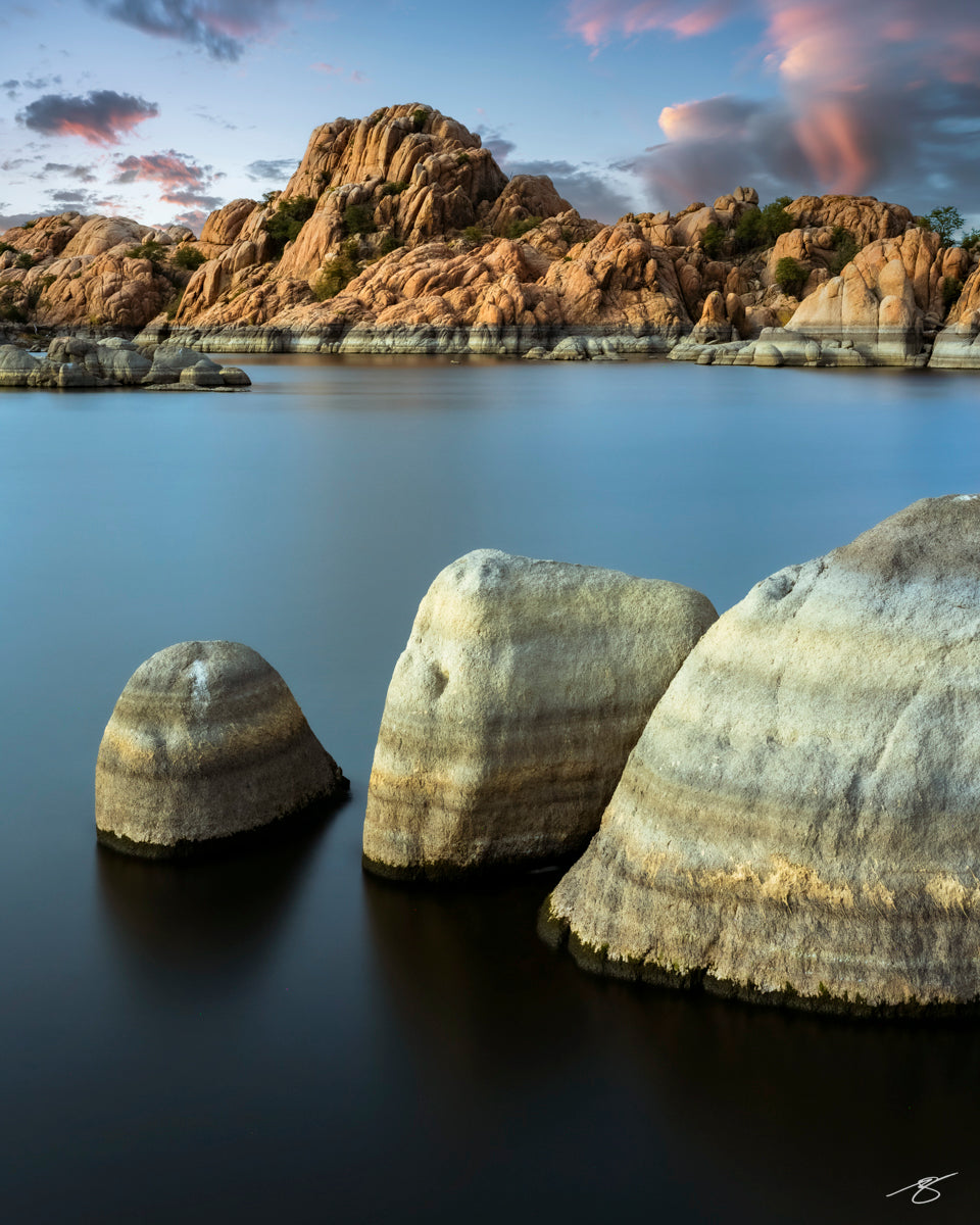 Fine art long-exposure photograph of Watson Lake in Prescott, Arizona, featuring the Granite Dells’ rounded rock formations, calm reflective water, and warm sunset tones. A serene desert landscape showcasing sculpted stone and peaceful evening light.