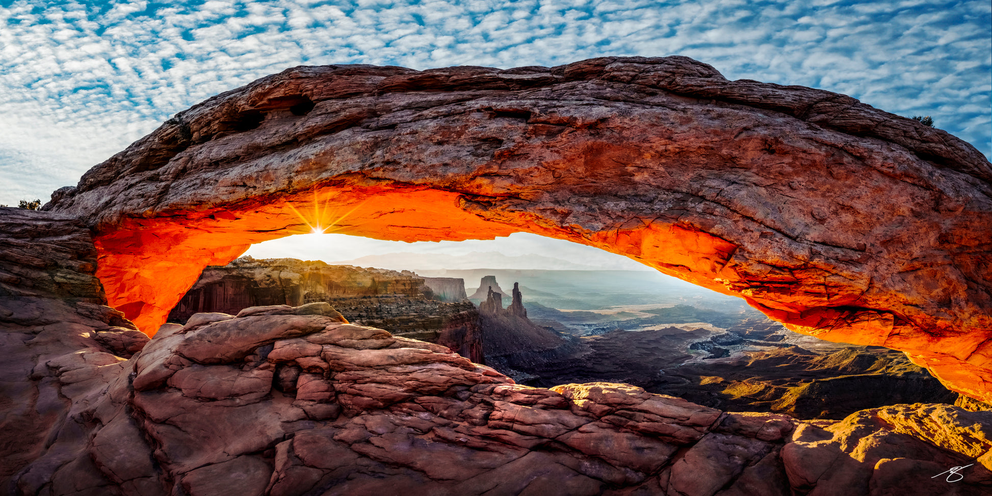 Mesa Arch illuminated by sunrise in Canyonlands National Park, Utah, overlooking the desert canyon landscape below