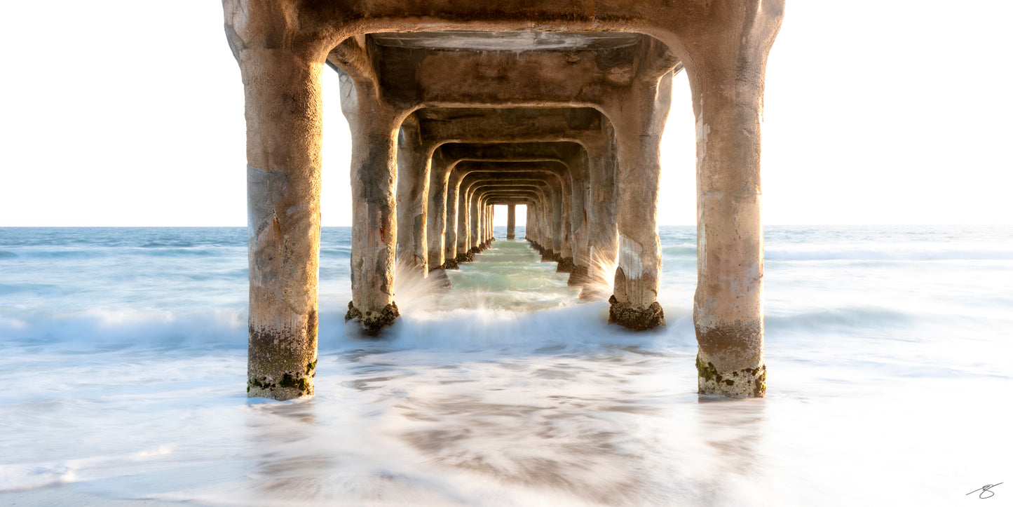 Limited edition Manhattan Beach Pier photography by Beau Jesse Johnston featuring flowing ocean waves beneath the pier along the California coast